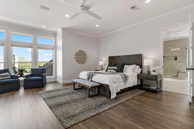 a spacious bedroom with a bed a couch and wooden floor