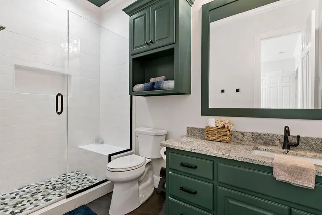 a bathroom with a granite countertop sink toilet and shower