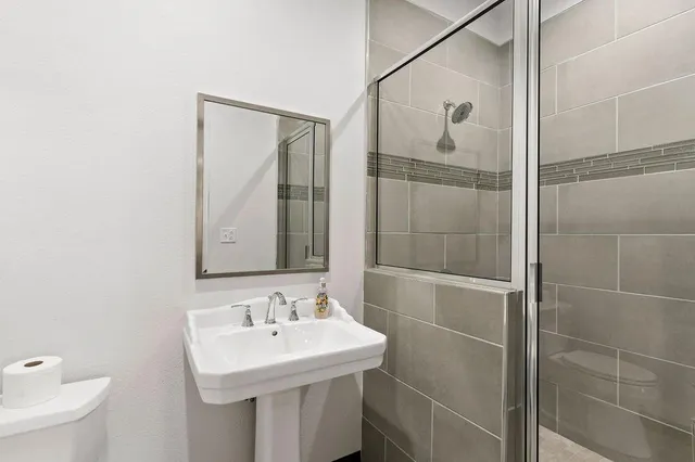 a bathroom with a sink and mirror with toilet