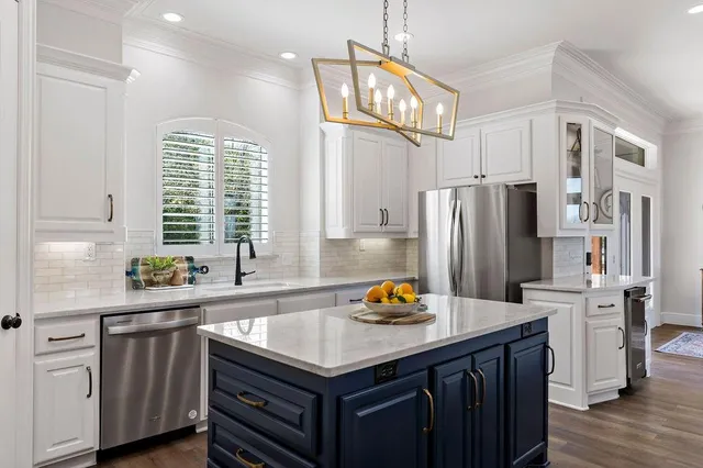 a kitchen with stainless steel appliances a sink a refrigerator and a window