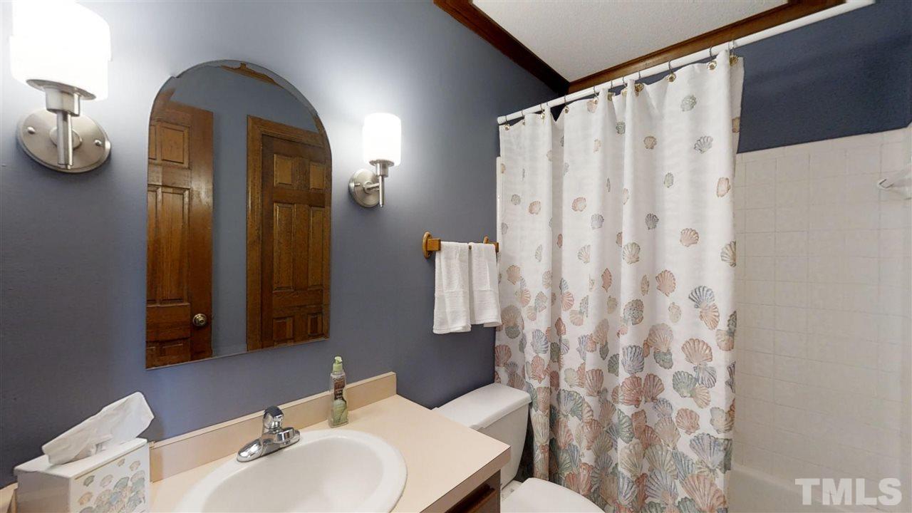 2704 Vestry Way Raleigh, NC 27613 - Photo 12 of 25 a bathroom with a sink and mirror with shower