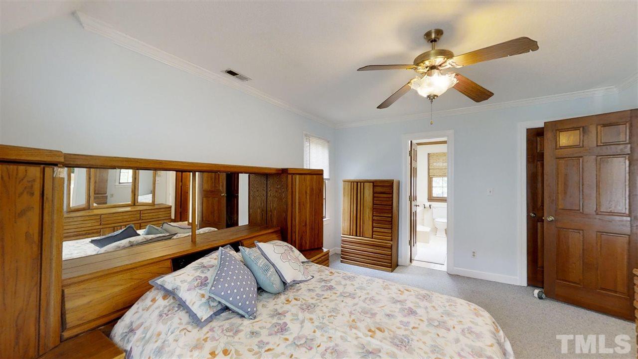 2704 Vestry Way Raleigh, NC 27613 - Photo 13 of 25 a bedroom with a bed and a chandelier