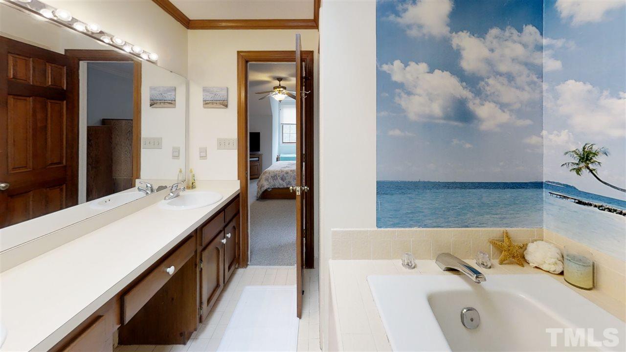 2704 Vestry Way Raleigh, NC 27613 - Photo 15 of 25 a bathroom with a tub sink and mirror