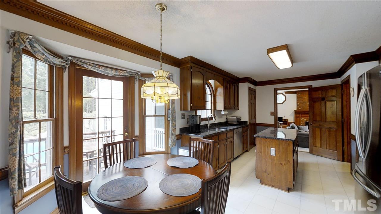 2704 Vestry Way Raleigh, NC 27613 - Photo 5 of 25 a dining room with furniture a chandelier and wooden floor