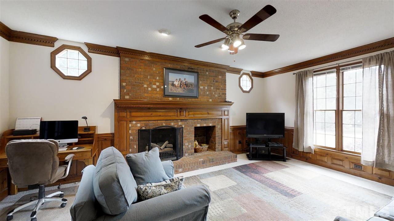 2704 Vestry Way Raleigh, NC 27613 - Photo 7 of 25 a living room with furniture a fireplace and a large window