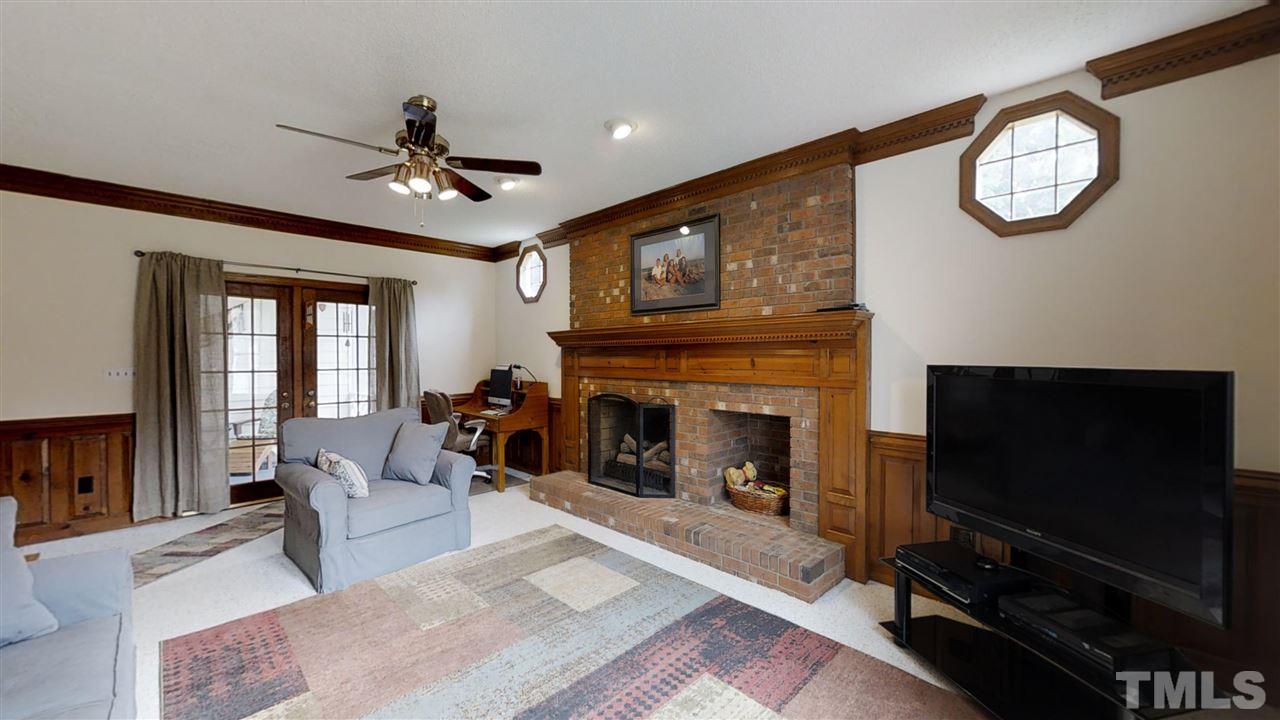 2704 Vestry Way Raleigh, NC 27613 - Photo 8 of 25 a living room with furniture a fireplace flat screen tv and couches