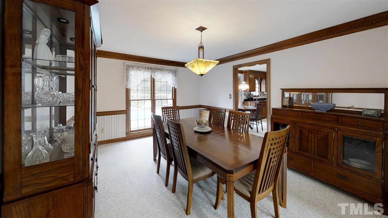 2704 Vestry Way Raleigh, NC 27613 - Photo 9 of 25 a dining room with furniture a chandelier and wooden floor