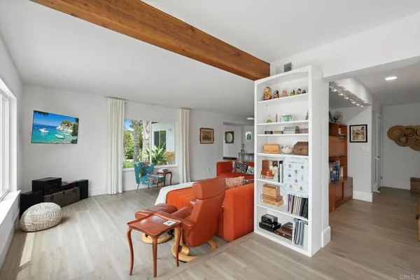 a living room with stainless steel appliances kitchen island granite countertop furniture a rug kitchen view and a chandelier