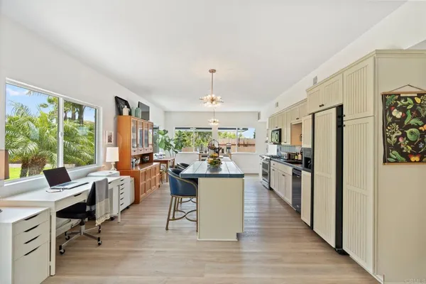 a kitchen with stainless steel appliances granite countertop a stove a sink dishwasher and cabinets with wooden floor