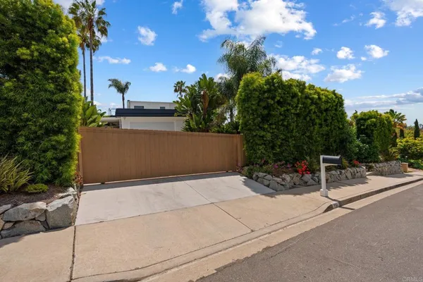 a view of a house with a yard and potted plants