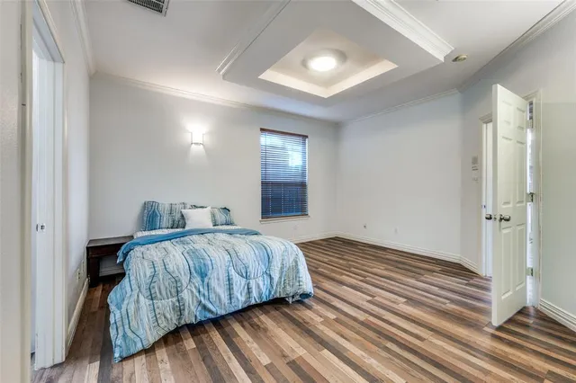 a bedroom with a bed and a lamp on dresser