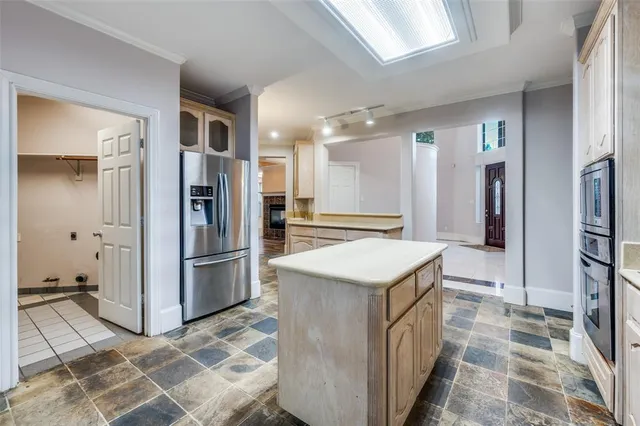 a kitchen with stainless steel appliances granite countertop a refrigerator a stove and a sink