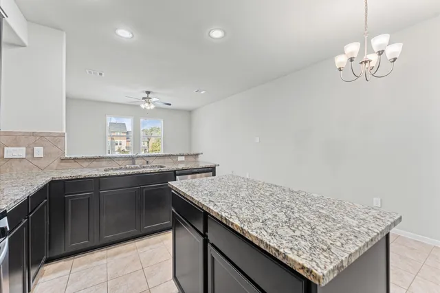 a kitchen with granite countertop cabinets and chandelier