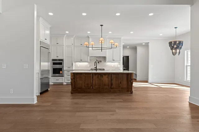 a kitchen with kitchen island white cabinets and stainless steel appliances