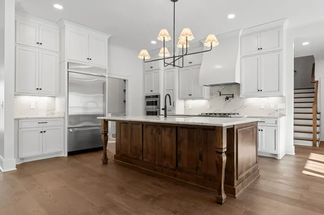 a view of a hallway with wooden floor and a living room