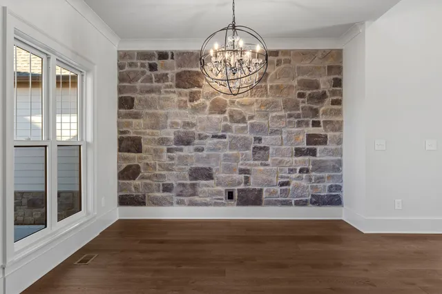 a view of a big room with wooden floor and a kitchen