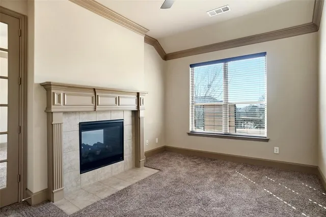 a view of an empty room with a fireplace and a window