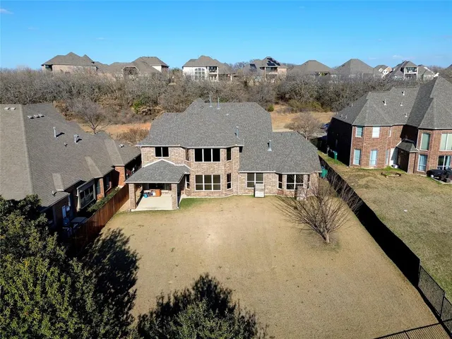 an aerial view of residential houses with outdoor space and trees
