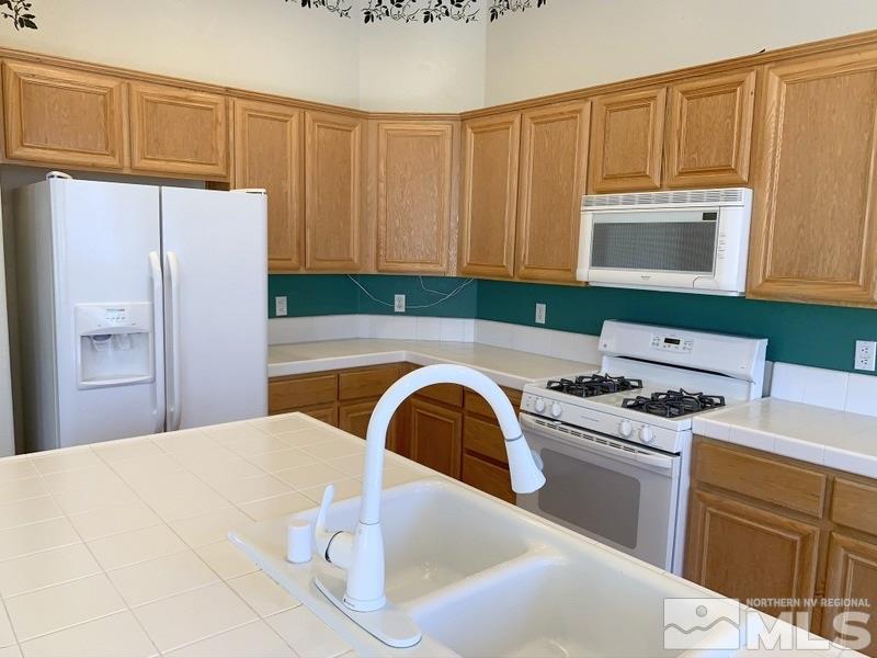 9625 Boulder Creek Lane Reno, NV 89521 - Photo 7 of 13 a kitchen with a sink a stove and refrigerator