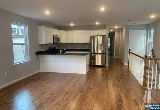 a kitchen with stainless steel appliances granite countertop a refrigerator and a stove top oven
