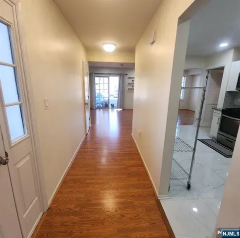 a view of a hallway with wooden floor and staircase