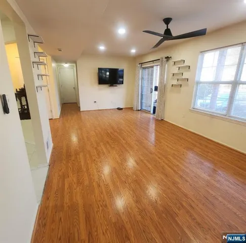 a view of a livingroom with furniture a ceiling fan and wooden floor