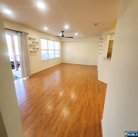 a view of empty room with wooden floor