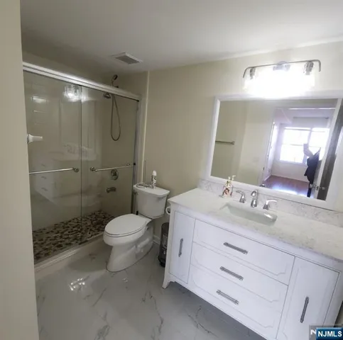 a bathroom with a sink toilet double vanity and shower