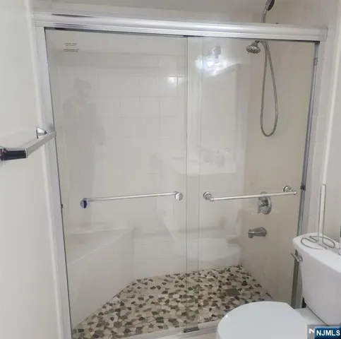 a bathroom with a shower toilet and sink
