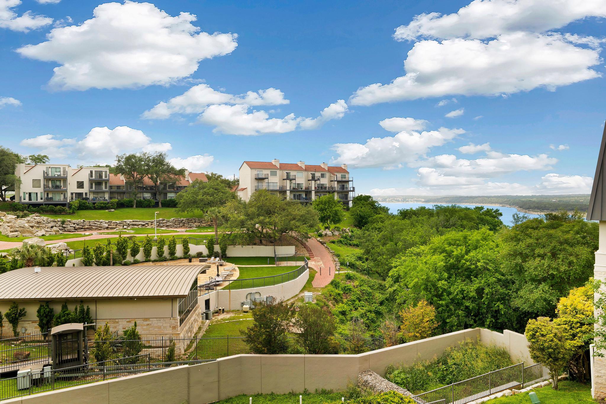 2918 Ranch Road 620, Unit J162 Austin, TX 78734 - Photo 26 of 26 Expansive outdoor setting featuring a view of Lake Travis, lush green trees, and multiple residential buildings