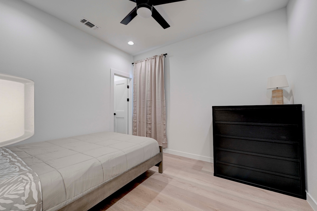 2220 Yellow Jacket Lane, Unit 1 Austin, TX 78741 - Photo 20 of 35 A well-lit bedroom with light wood flooring and a modern ceiling fan.