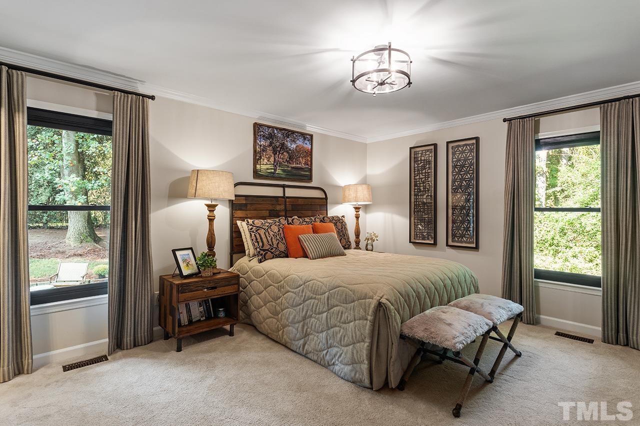 11605 Durant Road Raleigh, NC 27614 - Photo 21 of 42 a bedroom with a bed and a chandelier