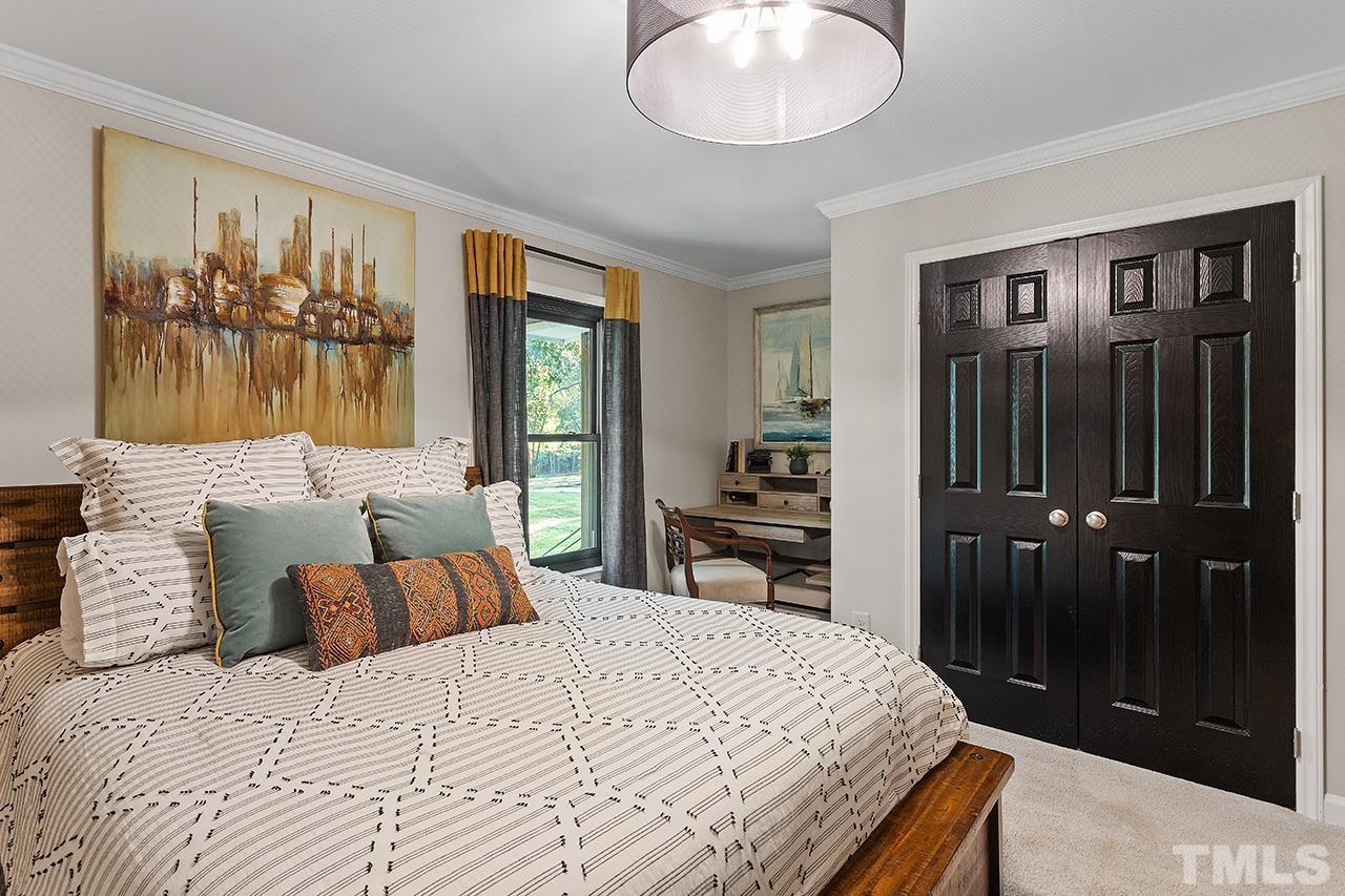 11605 Durant Road Raleigh, NC 27614 - Photo 25 of 42 a bedroom with a bed and a chandelier