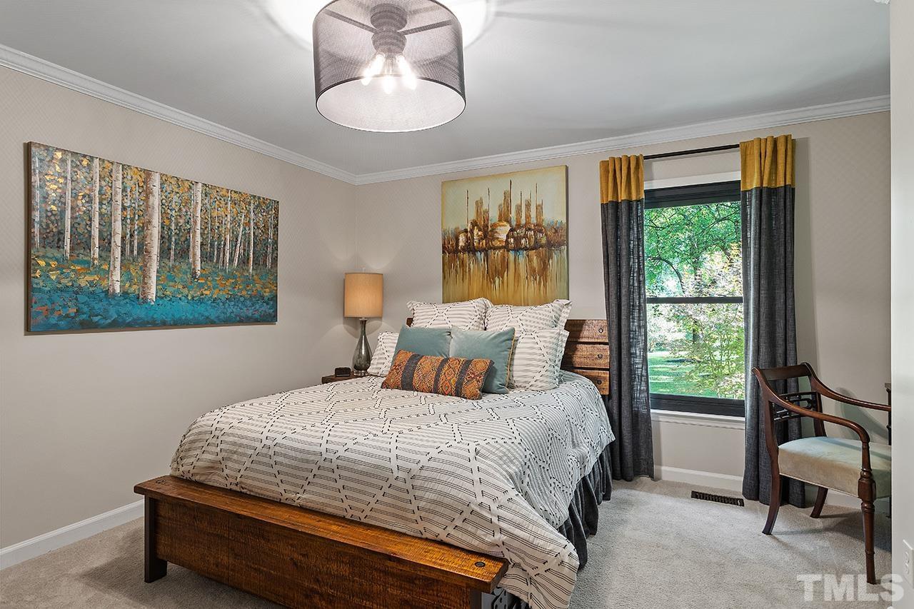 11605 Durant Road Raleigh, NC 27614 - Photo 26 of 42 a bedroom with a bed and a chandelier
