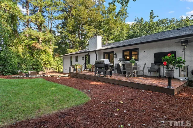 a view of a house with backyard and sitting area