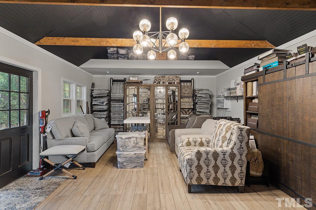 11605 Durant Road Raleigh, NC 27614 - Photo 38 of 42 a living room with furniture a chandelier and a wooden floor