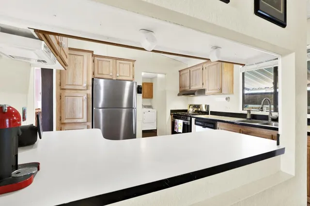 a kitchen with stainless steel appliances a refrigerator and a stove top oven