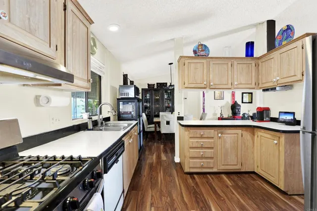 a kitchen with stainless steel appliances a stove a sink and a refrigerator