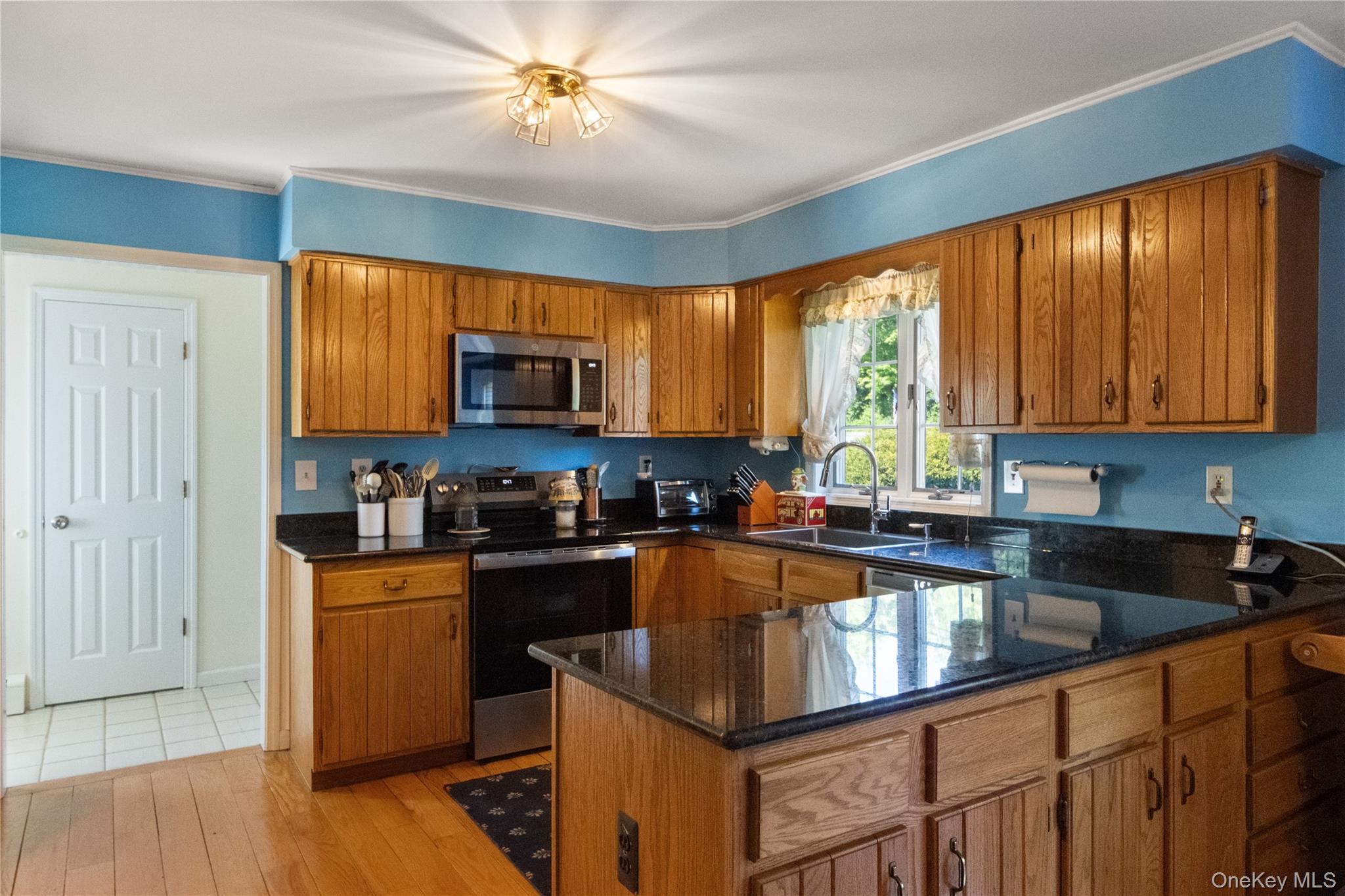 214 West Mombasha Road Monroe, NY 10950 - Photo 12 of 43 a kitchen with a stove a sink a microwave and cabinets