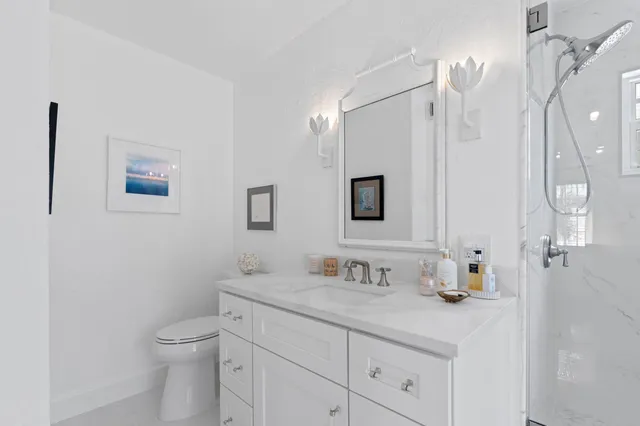 a bathroom with a granite countertop sink a toilet and a mirror