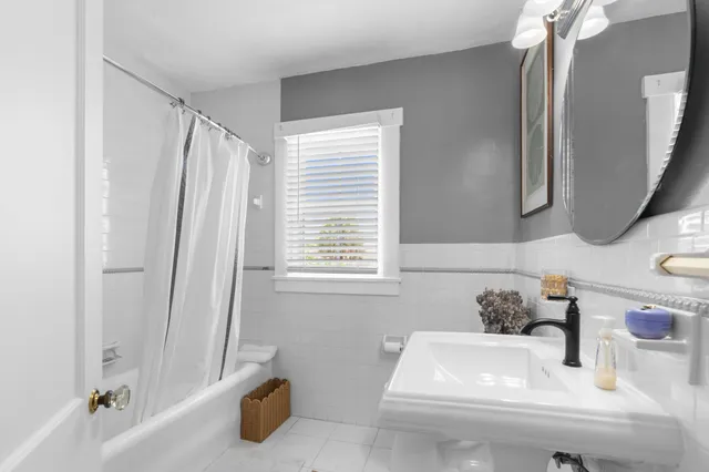 a bathroom with a tub sink and mirror