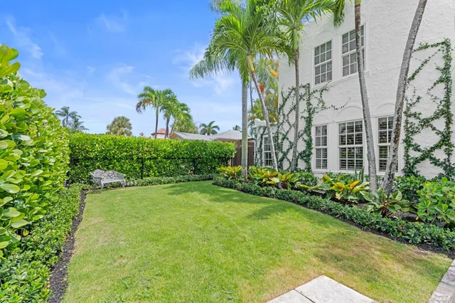 a front view of a multi story residential apartment building with yard and green space