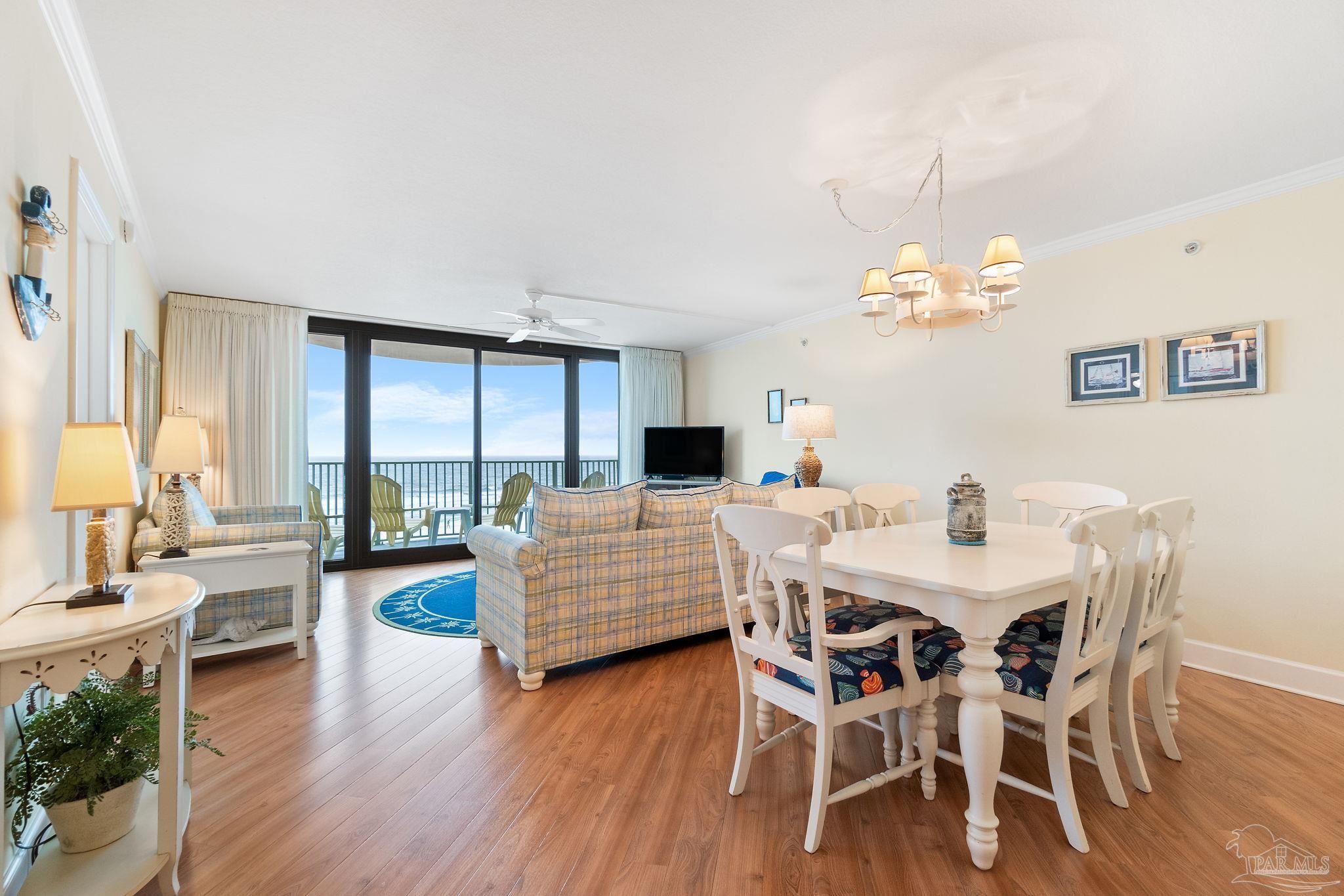 16785 Perdido Key Drive, Unit 503 Perdido Key, FL 32507 - Photo 5 of 38 a view of a dining room with furniture wooden floor and chandelier