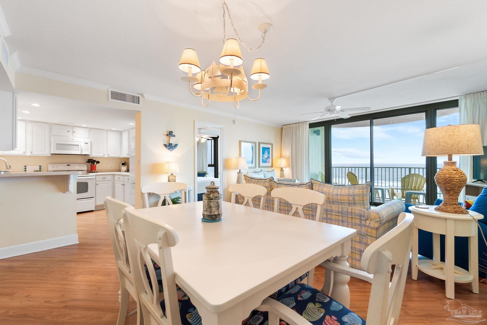 16785 Perdido Key Drive, Unit 503 Perdido Key, FL 32507 - Photo 7 of 38 a view of a dining room with furniture a chandelier and wooden floor
