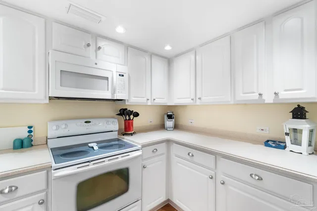 a kitchen with white cabinets and white appliances