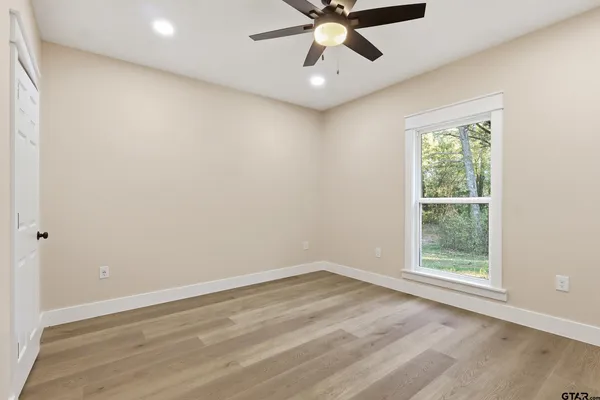 an empty room with a window and a fan