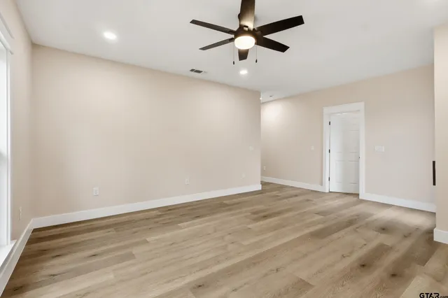a large white kitchen with a large window a sink and stainless steel appliances