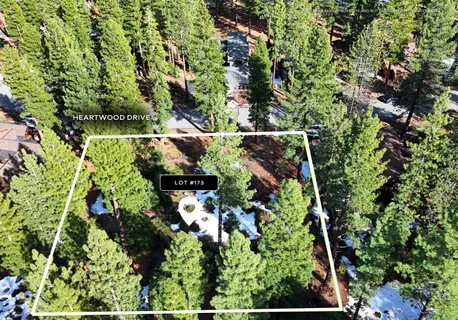 an aerial view of residential house with outdoor space and trees all around