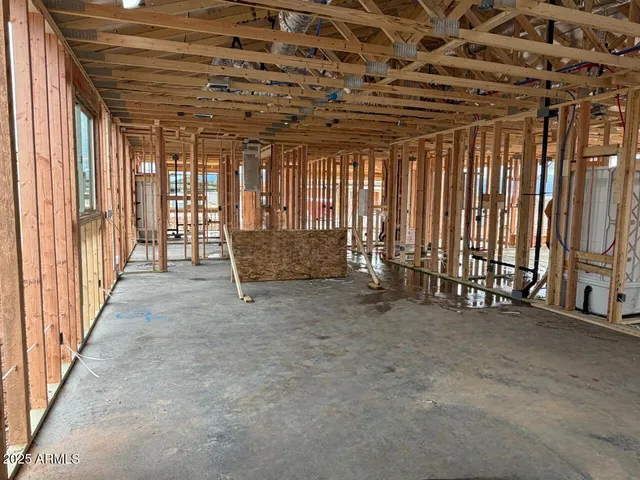 a view of an empty room with wooden floor and windows