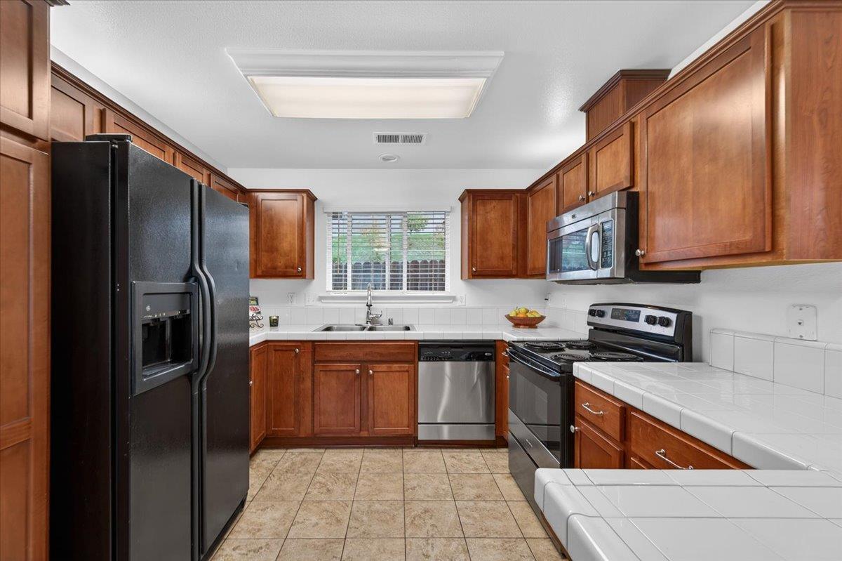 4776 East Rialto Avenue Fresno, CA 93726 - Photo 15 of 54 a kitchen with stainless steel appliances granite countertop a refrigerator and a stove top oven